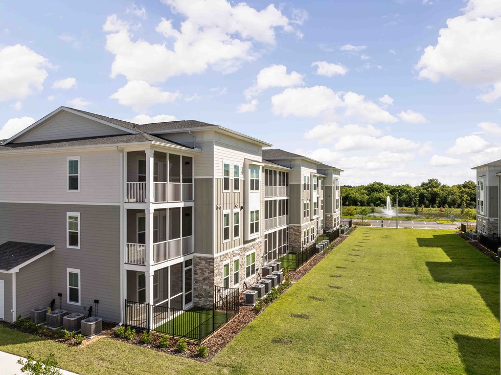 A large apartment complex with a green lawn in front.