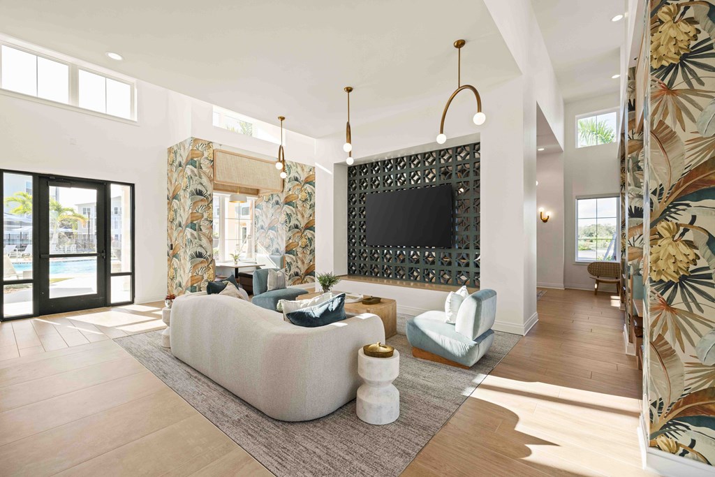A living room with a white couch and a black TV mounted on the wall.