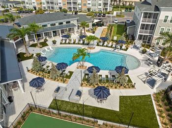 An aerial view of a resort with a pool and palm trees.