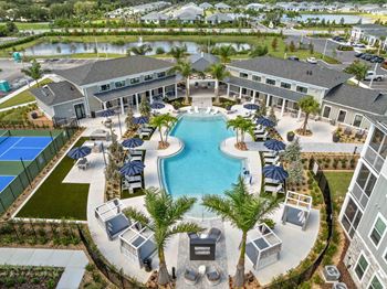 A large swimming pool surrounded by lounge chairs and umbrellas.