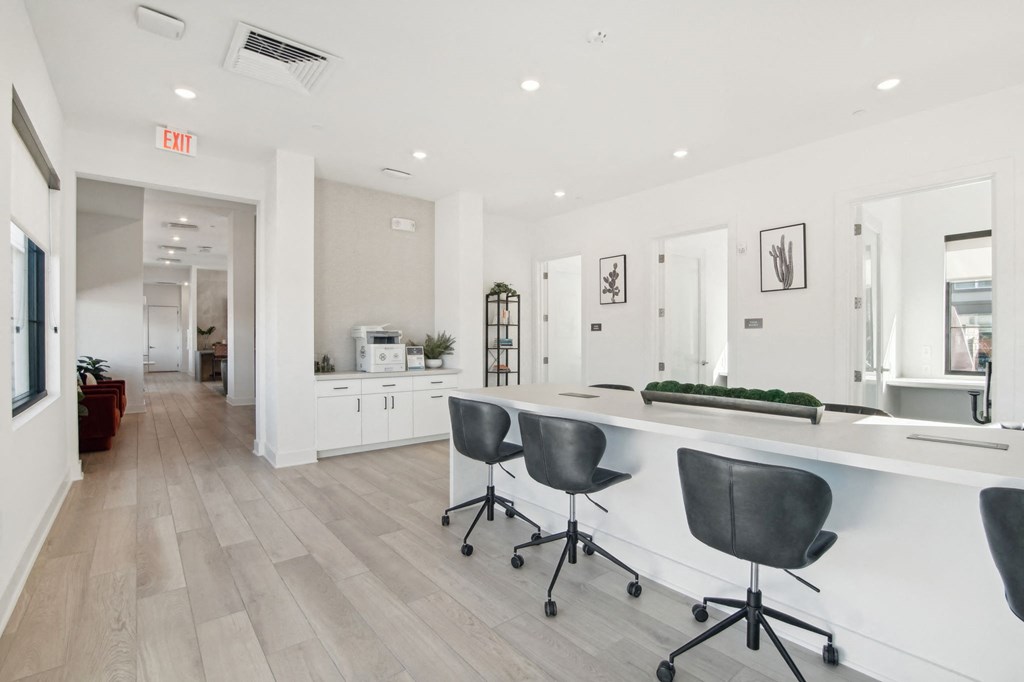a white office with a long counter and chairs at The Maddox Luxury Apartment Homes, Buckeye