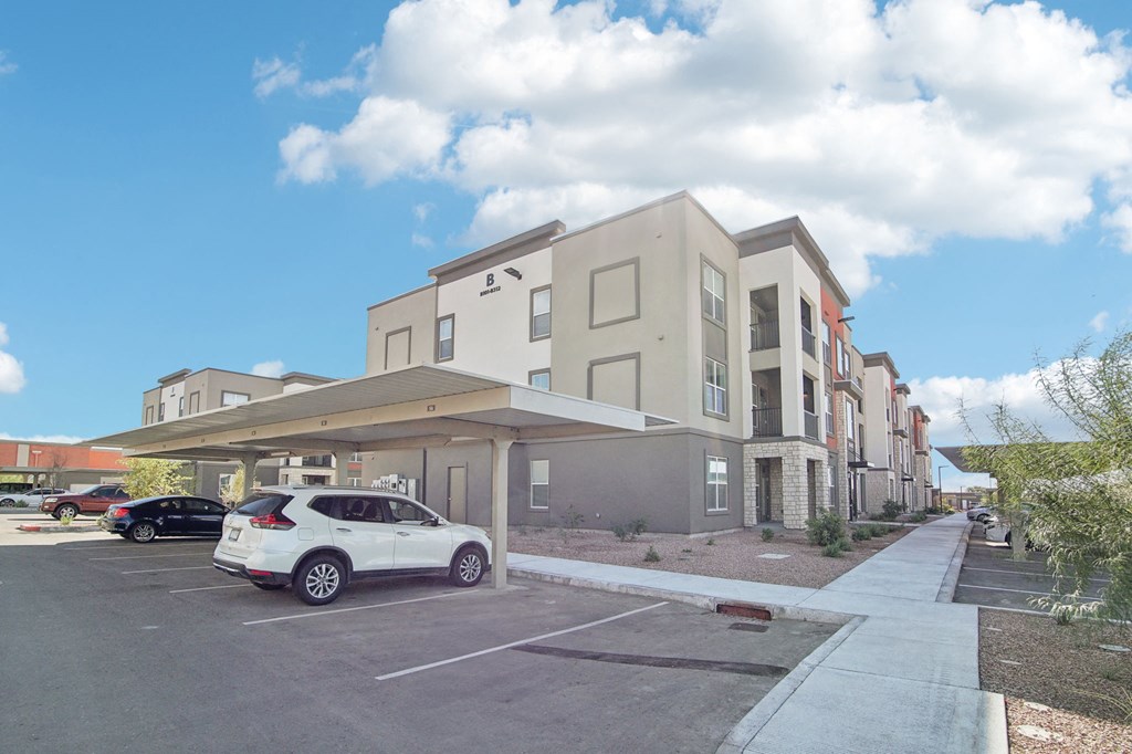 a car parked in a parking lot in front of a building at The Maddox Luxury Apartment Homes, Buckeye, AZ