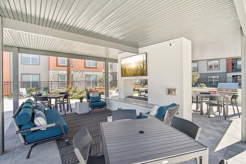 a living room with blue couches and chairs and a table at The Maddox Luxury Apartment Homes, Buckeye, 85326
