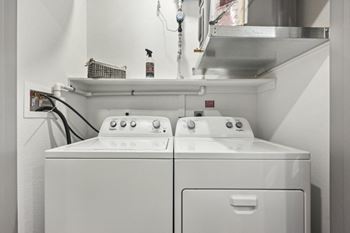 a washer and dryer in a laundry room with a sink at The Garrison Luxury Apartment Homes, Fountain Colorado
