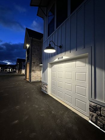 a white garage door on the side of a building at night at The BLVD at Wilson Crossings, Wyoming, MI
