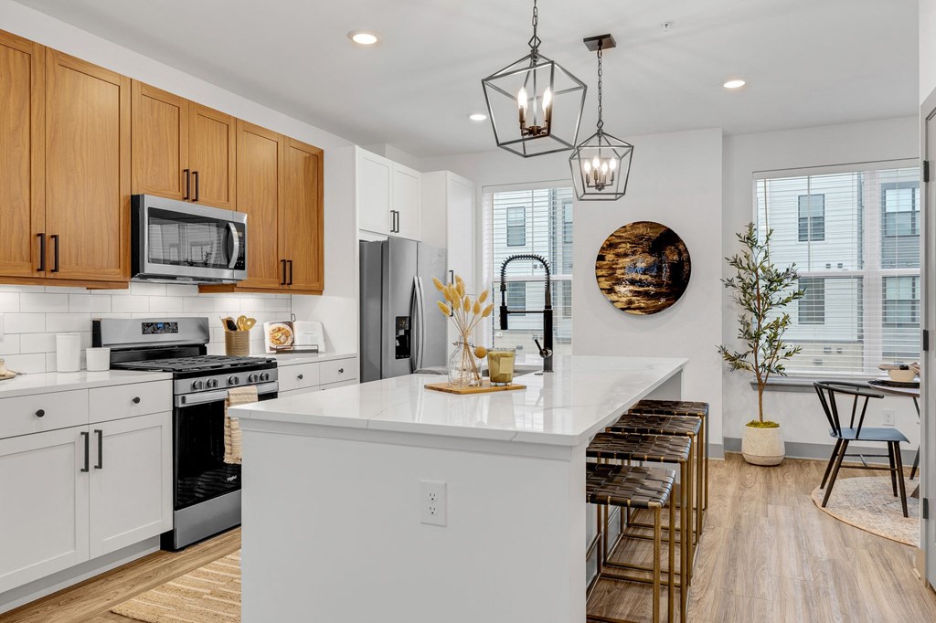 an open kitchen with a large white island with a counter top at Meridian at CityPlace, Woodbury