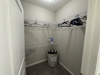 a walk in closet with a trash can and hanging racks at Watermark at Steele Crossing, Fayetteville, AR, 72703