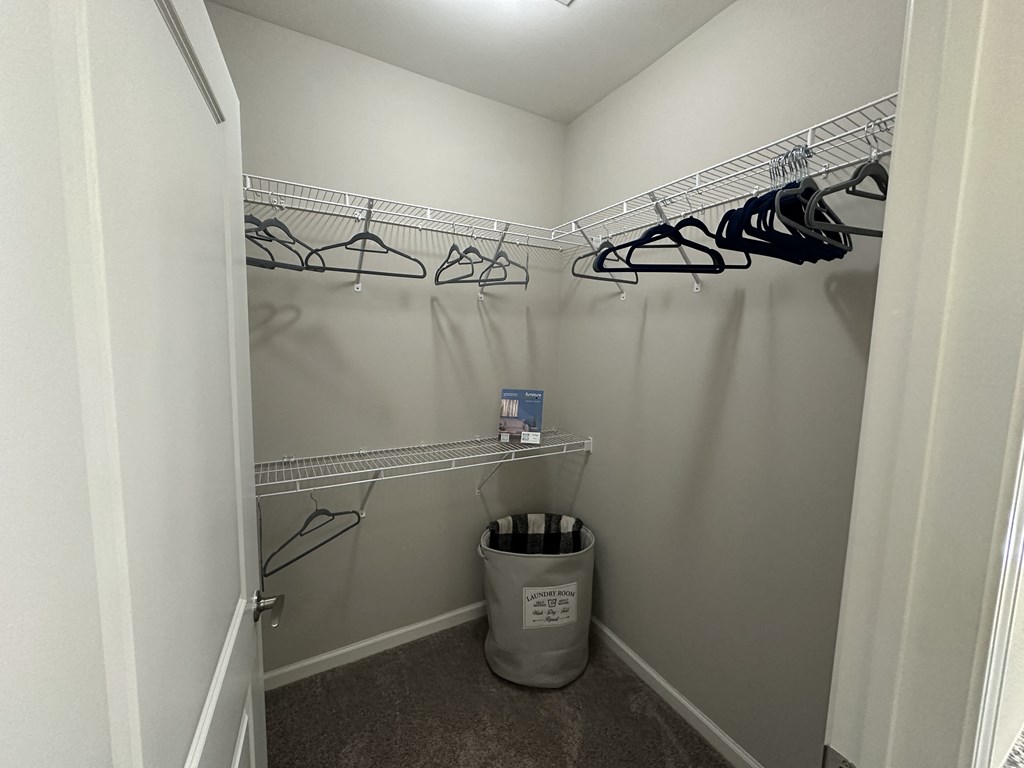 a walk in closet with a trash can and hanging racks at Watermark at Steele Crossing, Fayetteville, AR, 72703