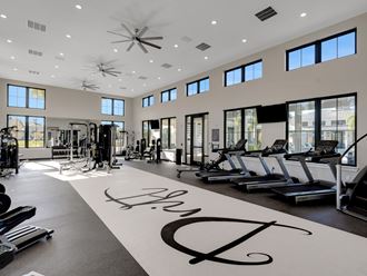 a gym with weights and cardio machines and a large sign on the floor