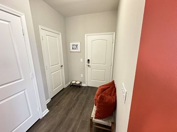 a living room with red walls and white doors at Watermark at Steele Crossing, Fayetteville, AR