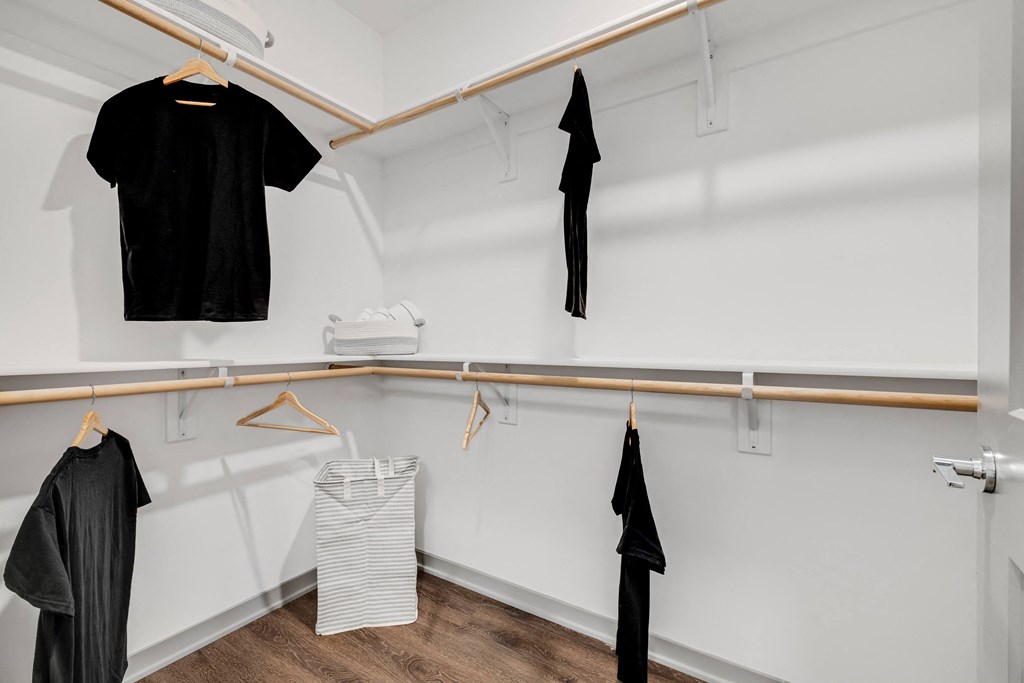 a walk in closet with white walls and a wooden rod with clothes hanging on it  at Prism at Diamond Ridge, Moon Township, PA, 15108