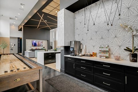 a large kitchen with black cabinets and white countertops and a large wooden table with a shuffle  at Prism at Diamond Ridge, Pennsylvania