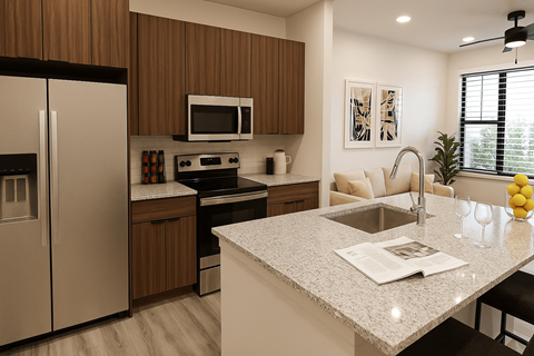 A modern kitchen with a granite countertop and stainless steel appliances at The Stadler Luxury Apartments, Bradenton, Florida