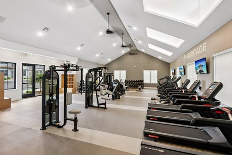 A gym with treadmills, weights, and exercise equipment.