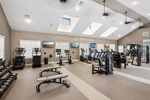 A gym with a variety of equipment including treadmills, exercise bikes, and weight machines.