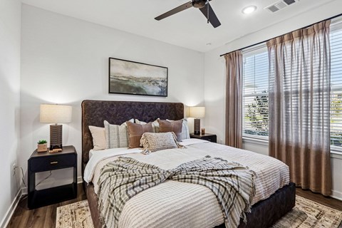 A bedroom with a large bed and a ceiling fan.