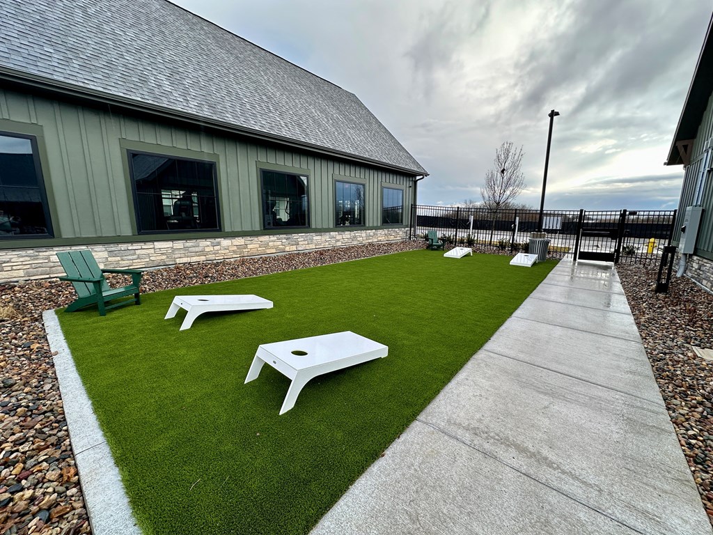 an outdoor area with benches and tables on grass at The Depot, Raymore, MO