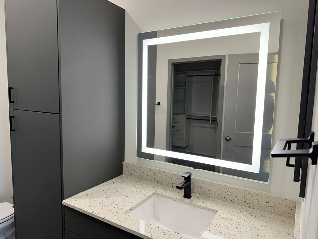 a bathroom with a sink and a mirror at The Depot, Raymore, MO, 64083