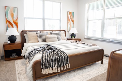 A bedroom with a bed covered in a black and white checkered blanket.