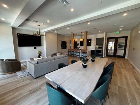 A modern dining room with a long table and chairs.