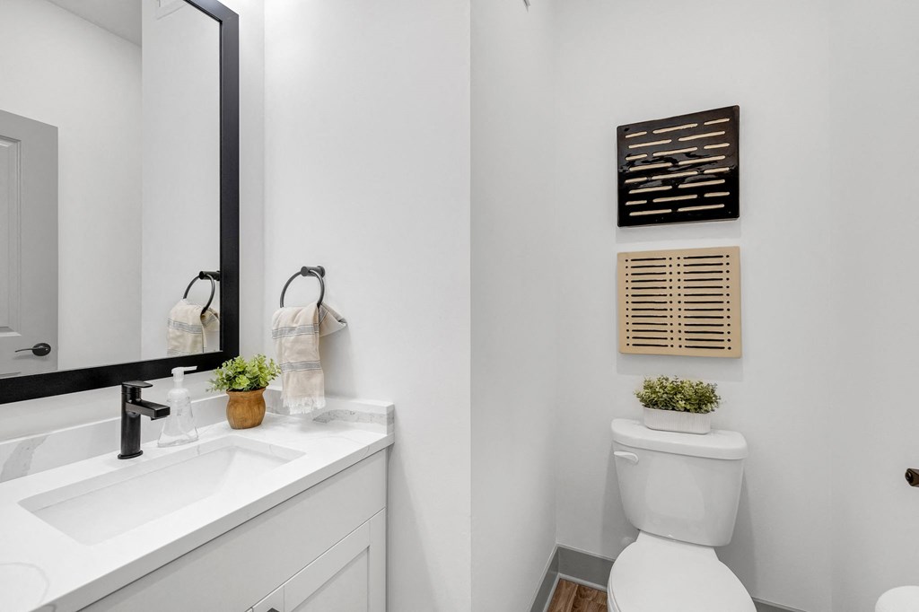 a white bathroom with a toilet and a sink at Meridian at CityPlace, Woodbury, MN