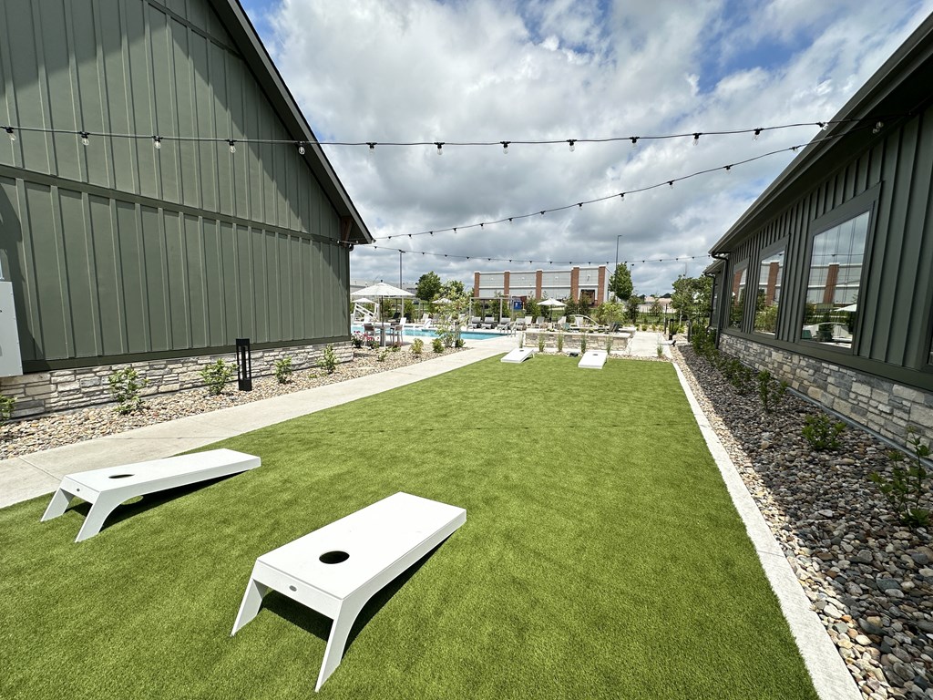 a lawn with benches and a pool in front of a building