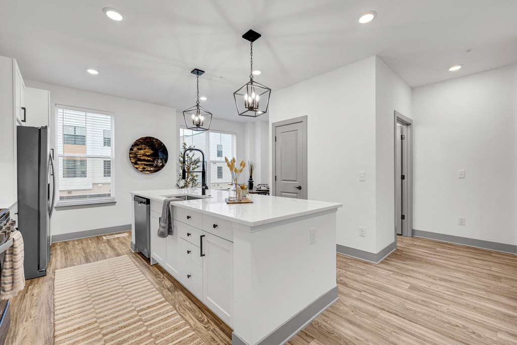 a white kitchen with a large island in the middle at Meridian at CityPlace, Woodbury