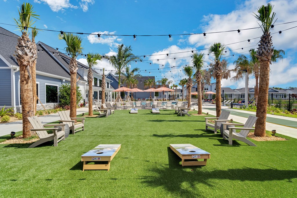 a grassy area with lounge chairs and tables at The Sophia, Venice