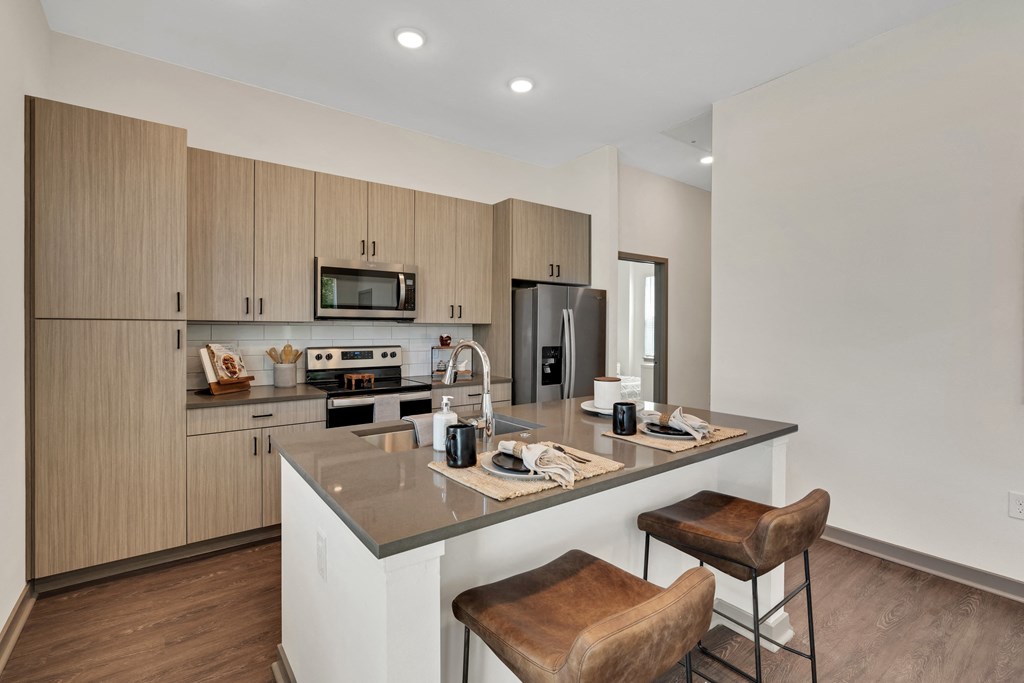 a kitchen with a large island with two stools  at The Sophia, Venice, 34275