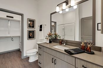 a bathroom with a large mirror and a white toilet at The Sophia, Venice, FL, 34275