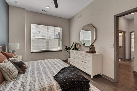 a bedroom with a large bed and a dresser with a mirror  at The Sophia, Venice, FL, 34275