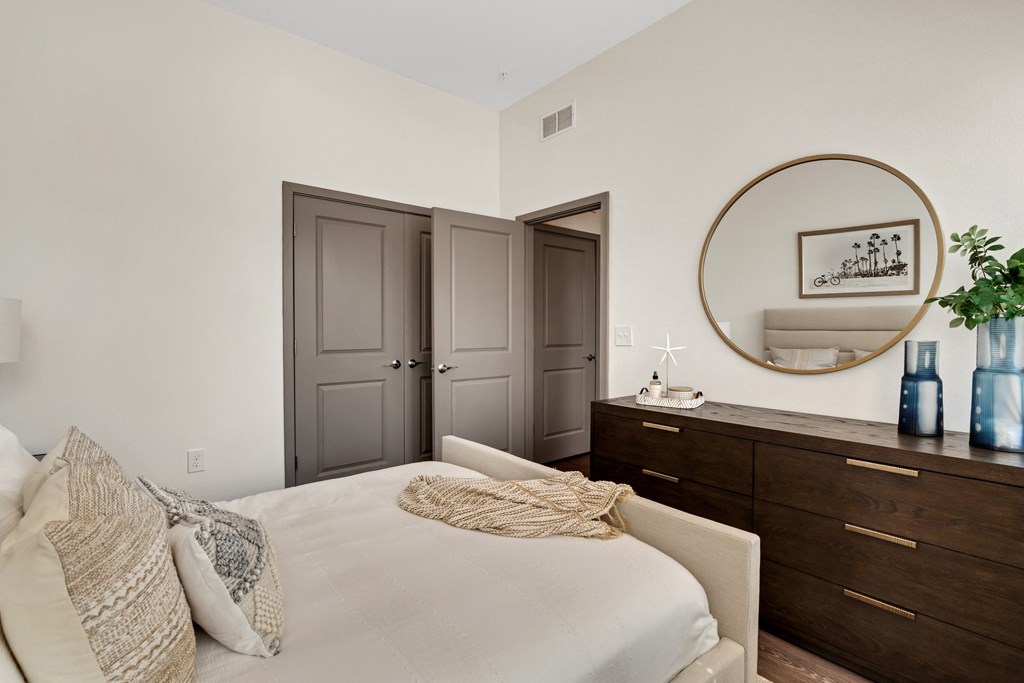 a bedroom with white walls and dark wood furniture  at The Sophia, Venice, FL, 34275