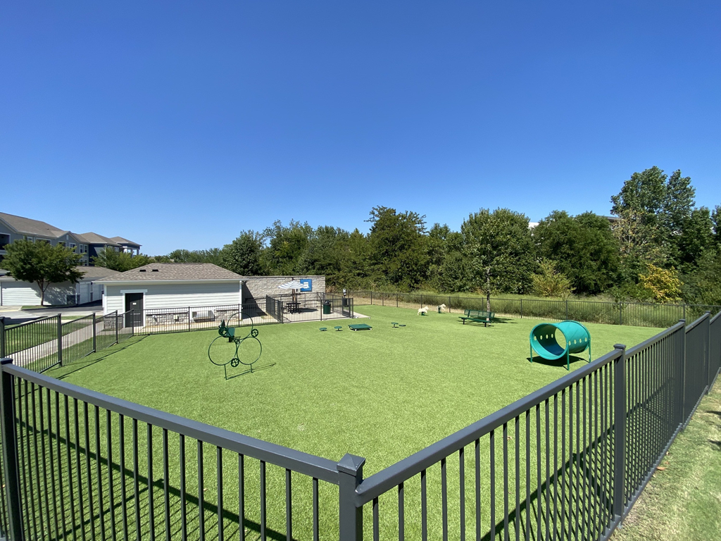 a fenced turf pet park with dog agilities  at Watermark at Steele Crossing, Fayetteville, Arkansas