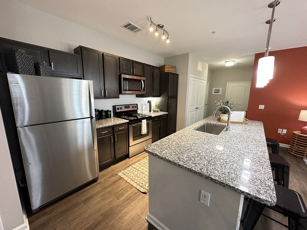 a kitchen with stainless steel appliances and granite counter tops at Watermark at Steele Crossing, Fayetteville, 72703