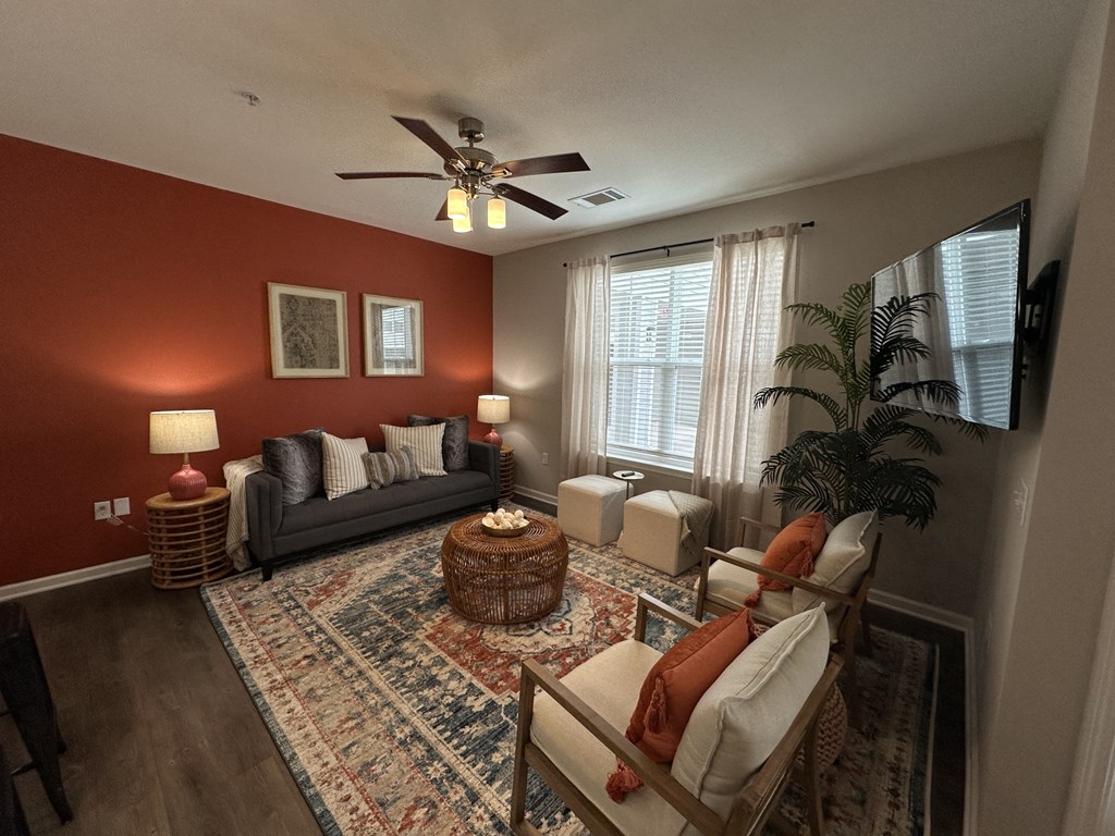 a living room with red walls and a ceiling fan at Watermark at Steele Crossing, Fayetteville, AR