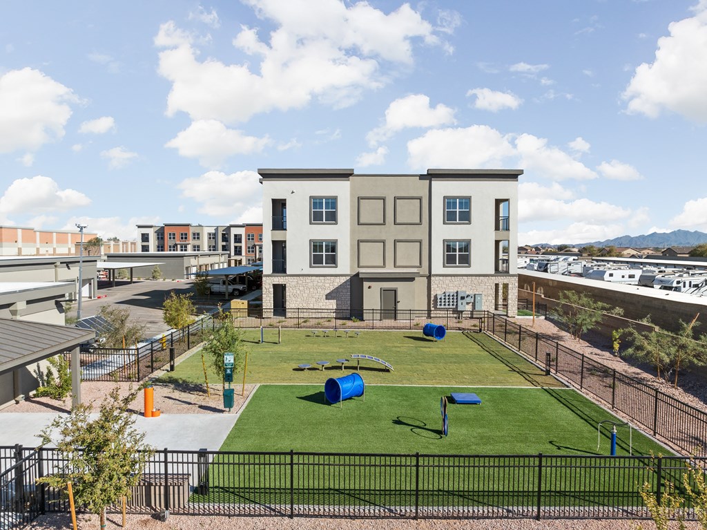 a park with grass and a playground in front of a building at The Maddox Luxury Apartment Homes, Buckeye, AZ, 85326