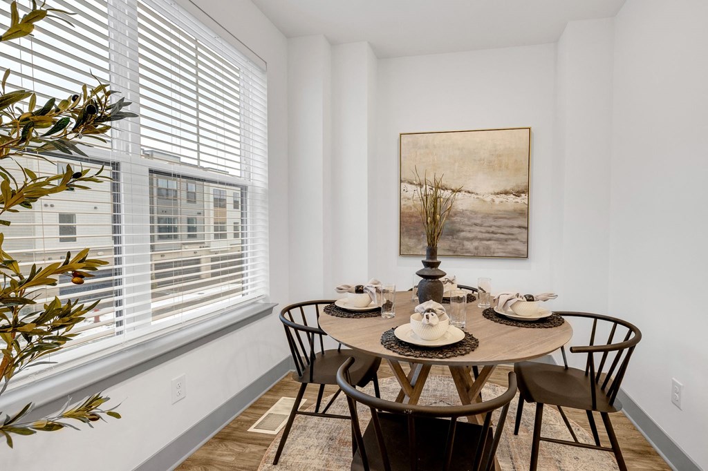 a dining room with a table and chairs and a large window at Meridian at CityPlace, Woodbury, MN 55125