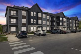 a rendering of a large apartment building with cars parked in front of it