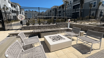 A patio with a fire pit and chairs at The Quinn Luxury Apartments, Pensacola, FL