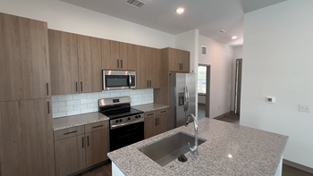 A kitchen with wooden cabinets and a granite countertop.