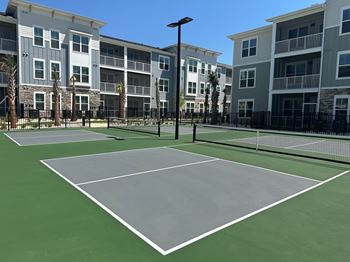 A tennis court is surrounded by apartment buildings at The Quinn Luxury Apartments, Pensacola