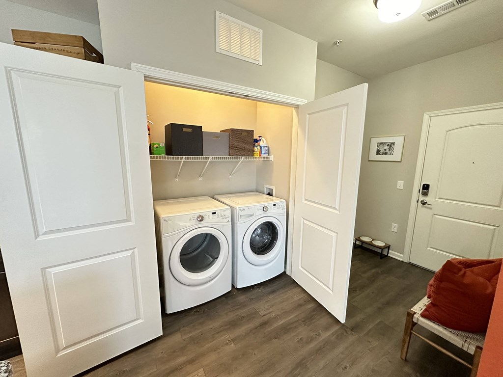 a laundry room with a washer and dryer and a shelf over the door at Watermark at Steele Crossing, Fayetteville, AR