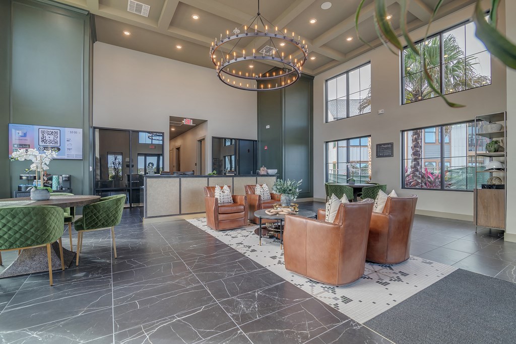 a lobby with chairs and tables and a large chandelier at Canter, Ocala, 34474