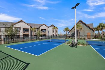 two tennis courts with apartments in the background at Canter, Ocala, FL, 34474