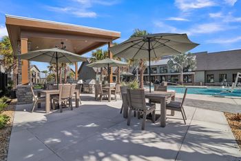 A patio with tables and chairs under umbrellas at Canter, Ocala, FL, Florida