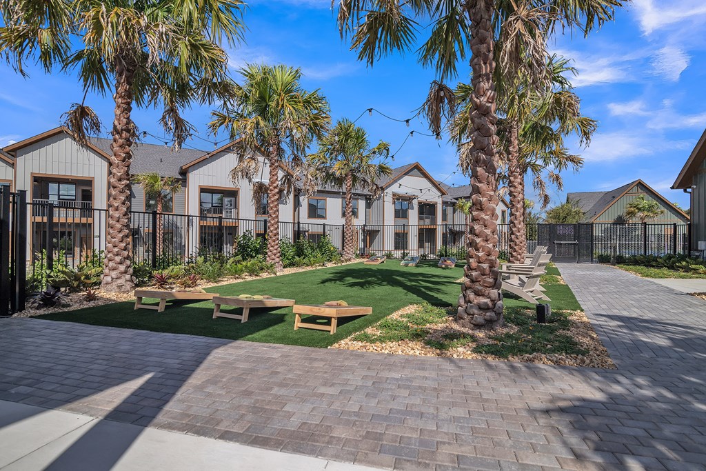 a picnic area with benches and palm trees in front of houses at Canter, Ocala, Florida