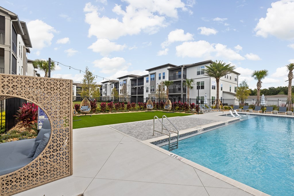 A large swimming pool in front of a building with a fence around it.
