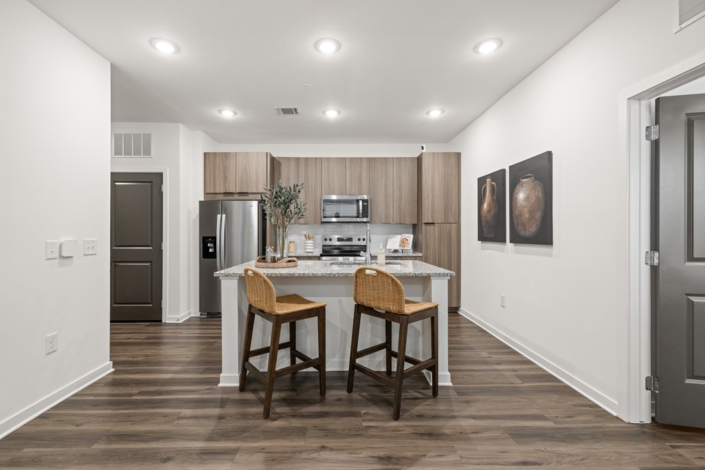 A kitchen with a table and two chairs in the middle of the room.