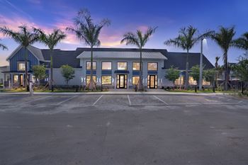 a parking lot in front of a building with palm trees at The Sophia, Venice, FL, 34275