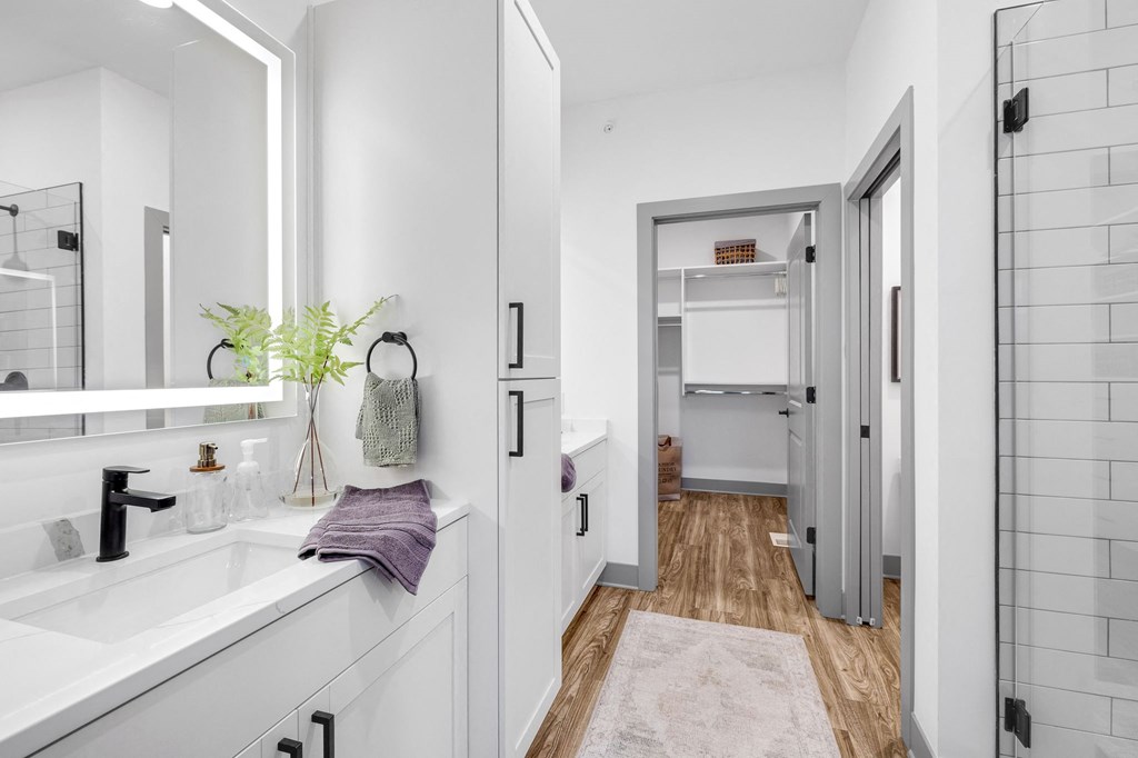 a white bathroom with a sink and a mirror at Meridian at CityPlace, Woodbury